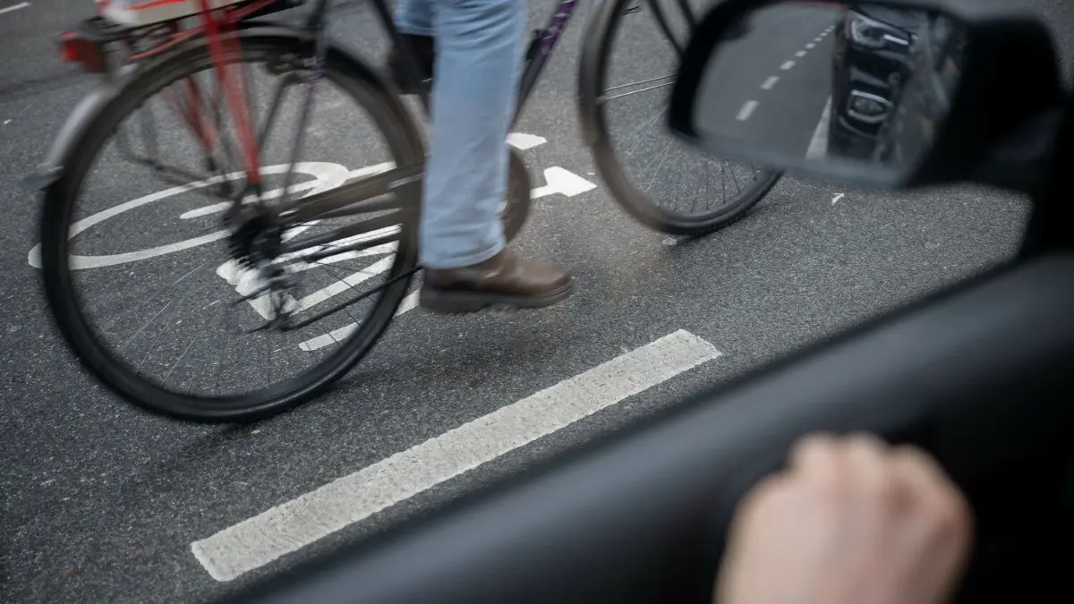 Streit nach Unfall: In Gransee kollidierte ein Fahrrad mit einem Auto. Die Besitzer gerieten daraufhin in Streit. (Symbolfoto)
PRODUKTION - 14.03.2023, Hessen, Frankfurt/Main: Ein Fahrradfahrer fährt auf einer Fahrradstraße an einem Schutzstreifen für geöffnete Türen an Autos vorbei. Der Schutzstreifen soll verhindern, dass Fahrradfahrer durch unachtsam geöffnete Türen verletzt werden. (zu dpa: Forderung nach mehr Sicherheit für Radfahrer gegen «Dooring»-Gefahr) Foto: Sebastian Gollnow/dpa +++ dpa-Bildfunk +++