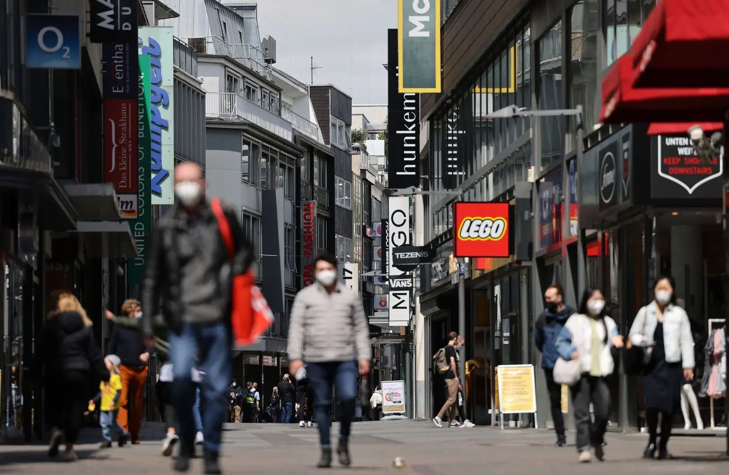 Passanten gehen in der Innenstadt von Köln durch die Geschäftsstraße Hohe Straße. In der Millionenstadt soll erst Ende Juni die Pflicht zum Tragen eine Maske in weiten Teilen des öffentlichen Lebens entfallen.