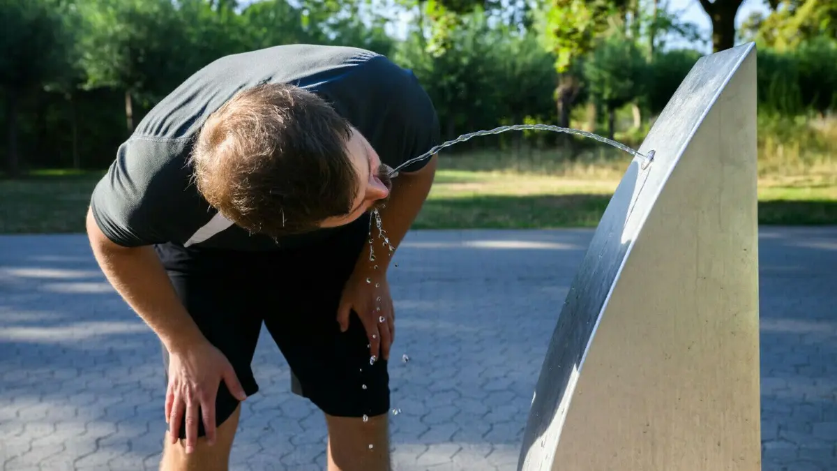 Gibt es öffentliche Trinkwasserbrunnen bald überall? Eine neue Verordnung zum Trinkwasser schreibt die Spender vor und soll die Verbraucher besser schützen.
10.08.2022, Niedersachsen, Hannover: Ein Sportler trinkt Wasser an einem öffentlichen Trinkwasserspender der Stadt Hannover. Das Bundeskabinett befasst sich mit Trinkwasser. Dafür will die Ministerrunde einen Gesetzentwurf des Bundesumweltministeriums auf den Weg bringen. Das Ziel ist es, Bürgerinnen und Bürgern verstärkt Trinkwasser aus dem Leitungsnetz in der Öffentlichkeit zur Verfügung zu stellen. Foto: Julian Stratenschulte/dpa +++ dpa-Bildfunk +++