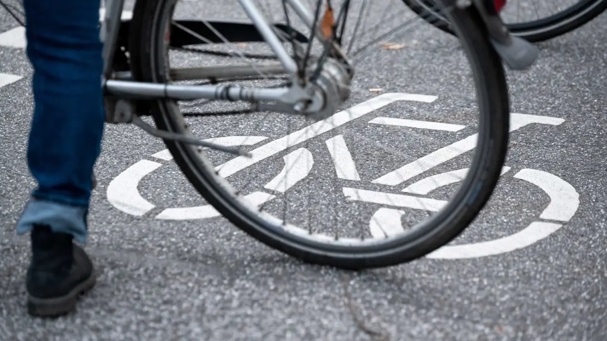 Fahrradfahrer (Symbolbild): ARCHIV - 31.10.2021, Hamburg: Ein Fahrrad-Symbol ist auf der Fahrbahn einer Straße hinter einem Fahrrad zu sehen. (zu dpa: «14-jähriger Radfahrer stürzt und wird schwer verletzt») Foto: Jonas Walzberg/dpa +++ dpa-Bildfunk +++