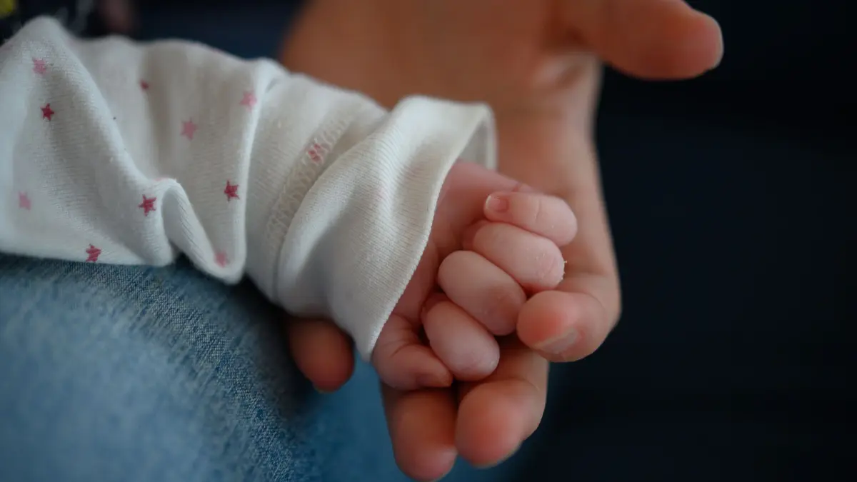Neugeborenes: ARCHIV - 02.02.2020, Baden-Württemberg, Stuttgart: Die Hand eines zwei Wochen altes Neugeborenen liegt in der Hand seiner Mutter. In Polen hat eine 13-jährige Schülerin auf einer Klassenfahrt ein Baby zur Welt gebracht. (zu dpa: «Polen: 13-Jährige bringt auf Klassenfahrt Kind zur Welt») Foto: Sebastian Gollnow/dpa +++ dpa-Bildfunk +++