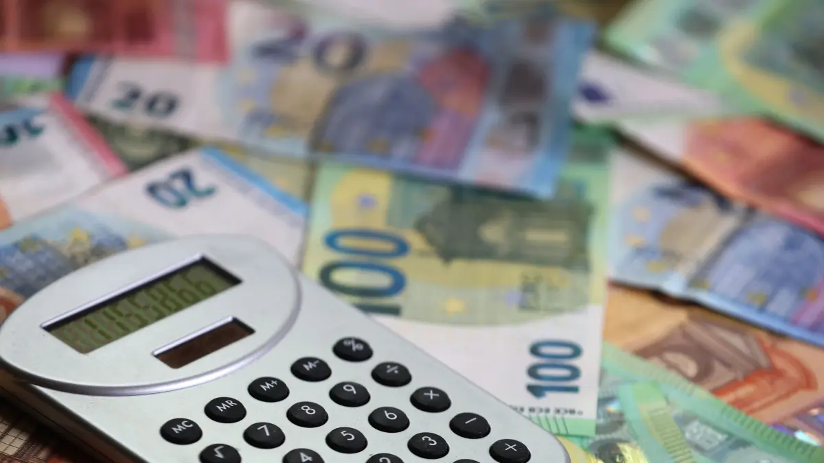 ILLUSTRATION Ein Taschenrechner liegt auf verschiedenen Euro-Banknoten. (zu dpa: «Rund ein Drittel der Kommunen noch ohne genehmigten Haushalt») +++ dpa-Bildfunk +++