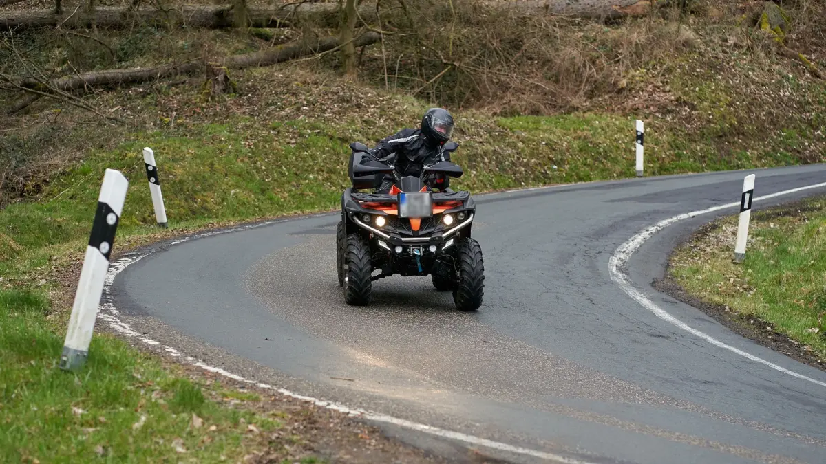 27.03.2021, Rheinland-Pfalz, Nievern: Ein Quadfahrer ist auf einer Landstrasse unterwegs. Das Risiko, bei einem Unfall schwer verletzt oder sogar getötet zu werden, ist laut Unfallexperte Brockmann bei einem Quad zehnmal höher als beim Auto. (zu dpa: Wo der Spaß aufhört: Vom riskanten Vergnügen mit dem Quad") Foto: Thomas Frey/dpa - ACHTUNG: Das Kennzeichen des Fahrzeugs wurde aus rechtlichen Gründen gepixelt +++ dpa-Bildfunk +++