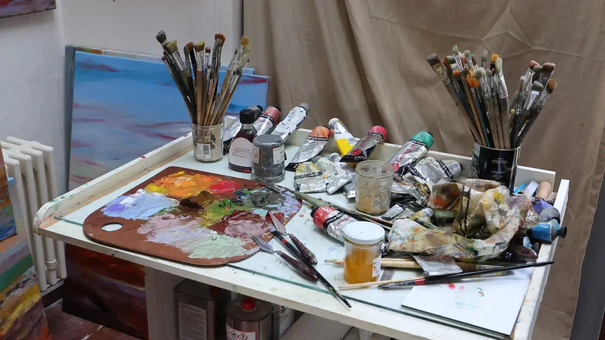 Tag der offenen Ateliers und Werkstätten: 21.09.2024, Thüringen, Weimar: Pinsel und Farben liegen auf einem Tisch in einem Maleratelier beim Tag der offenen Ateliers und Werkstätten. Für Besucher besteht die Möglichkeit, neue Tendenzen zeitgenössischer Kunst unmittelbar am Ort des Geschehens kennenzulernen und mit den Künstlern ins Gespräch zu kommen. Foto: Bodo Schackow/dpa +++ dpa-Bildfunk +++
