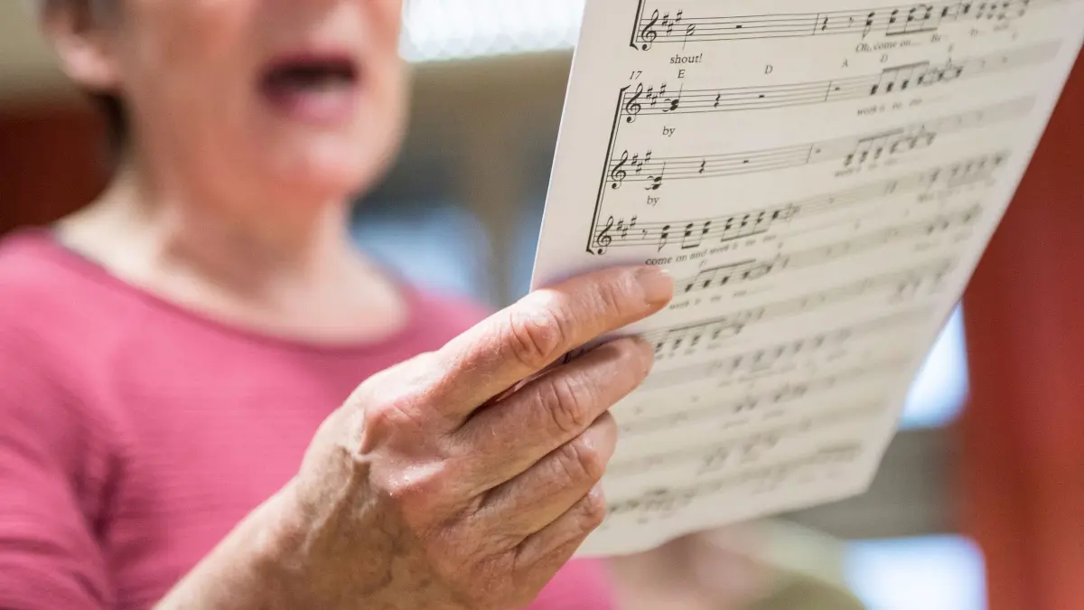 Eine Seniorin singt in einem Chor: ARCHIV - Ganz im Moment, verschmolzen mit der Musik: Singen hat nicht nur positive Auswirkungen auf den Körper, sondern auch auf die Psyche. (zu dpa: «Im Alter: Warum Singen so guttut - und wie Sie sich trauen») Foto: Robert Günther/dpa-tmn - Honorarfrei nur für Bezieher des dpa-Themendienstes +++ dpa-Themendienst +++