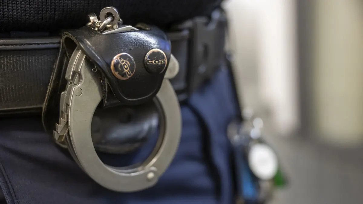 ARCHIV - 22.11.2023, Bayern, München: Eine Handschelle hängt am Gürtel eines Polizisten der Polizeiinspektion 11. (zu dpa: «Mutmaßlicher Geldfälscher in Untersuchungshaft») Foto: Peter Kneffel/dpa +++ dpa-Bildfunk +++