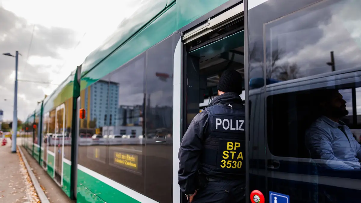 PRODUKTION - 20.11.2023, Baden-Württemberg, Weil am Rhein: Ein Beamter der Bundespolizei steht im Eingangsbereich einer aus Basel kommende Straßenbahn. Die Bundespolizei kontrolliert derzeit verstärkt Reisende, so auch an der Grenze zur Schweiz. Bundesinnenministerin Faeser (SPD) hatte stationäre Grenzkontrollen an den Grenzen zu Polen, Tschechien und der Schweiz am 16. Oktober zunächst für zehn Tage angemeldet und dann mehrfach verlängert. Sie begründete diesen Schritt mit dem Bekämpfen von irregulärer Zuwanderung und Schleuserkriminalität. (zu dpa: «Freiburger Behördenchefin: Grenzkontrollen sind «wichtiger Baustein»») Foto: Philipp von Ditfurth/dpa +++ dpa-Bildfunk +++