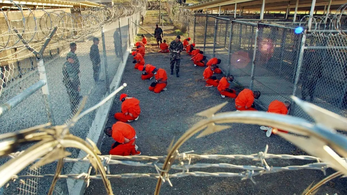 Guantánamo-Häftlinge: ARCHIV - 18.01.2002, Kuba, Guantanamo Bay: Ein von der US-Armee herausgegebenes Foto zeigt in orangefarbene Overalls gekleidete Häftlinge, die im Camp X-Ray auf dem US-Marinestützpunkt Guantanamo Bay auf Kuba auf dem Boden knien. (zu dpa: «Migranten nach Guantánamo - Trumps neuer umstrittener Plan») Foto: Shane T. McCoy/epa/dpa +++ dpa-Bildfunk +++