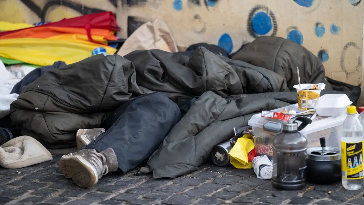 Schlafplatz in der Innenstadt: ARCHIV - 14.02.2023, Baden-Württemberg, Stuttgart: Eine Person liegt in der Innenstadt unter einem Schlafsack. Die Liga der Freien Wohlfahrtspflege hat in einer Pressekonferenz ihre jährliche Erhebung zur Unterstützung von Menschen in sozialer Ausgrenzung und Wohnungsnot vorgestellt. (zu dpa: «Liga: Dramatische Wohnungsnot – Wer stark betroffen ist») Foto: Marijan Murat/dpa +++ dpa-Bildfunk +++