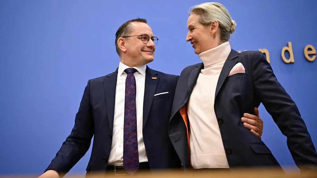 Co-leader of Germany's far-right Alternative for Germany (AfD) party and her party's top candidate for Chancellor Alice Weidel and co-leader Tino Chrupalla hug at the end of their press conference in Berlin, on February 24, 2025, one day after the German federal elections. The far-right Alternative for Germany (AfD) party celebrated a record election result on February 23, 2025 that fuelled its wildest hopes of one day entering government. (Photo by Tobias SCHWARZ / AFP)