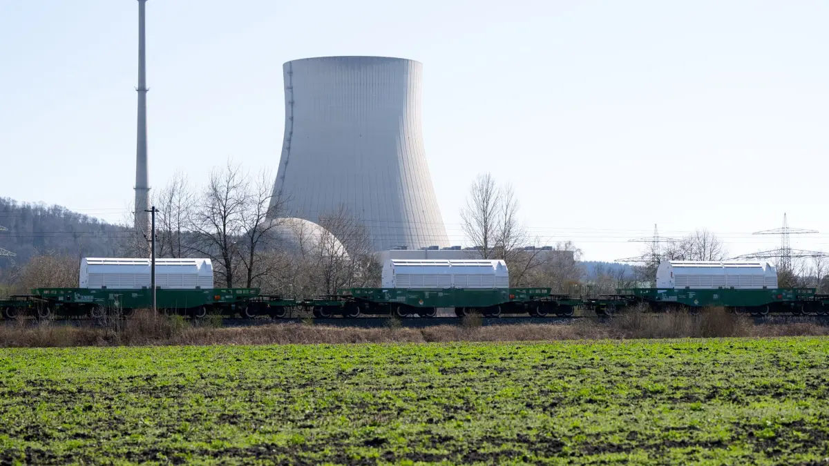 Castor-Transport: 03.04.2025, Bayern, Niederaichbach: Ein Zug mit Castor-Behältern fährt am Kernkraftwerk Isar entlang. Bei dem Atommüll handelt es sich um Überreste von Brennelementen aus deutschen Kernkraftwerken, die in England aufgearbeitet wurden. In Niederaichbach bei Landshut sollen die hoch radioaktiven Atomabfälle nach Angaben der Gesellschaft für Nuklear-Service (GNS) zwischengelagert werden. Foto: Sven Hoppe/dpa +++ dpa-Bildfunk +++