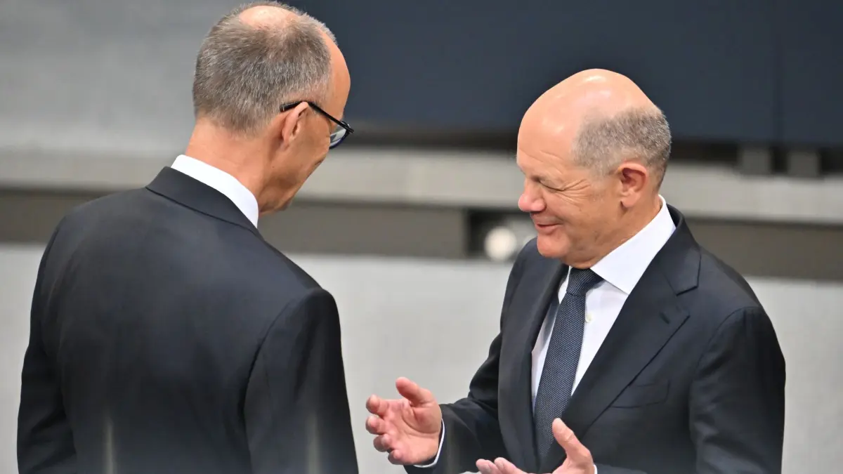 Bundestag - Kanzlerwahl: 06.05.2025, Berlin: Der designierte Bundeskanzler Friedrich Merz (CDU, r) spricht im Bundestag bei der Kanzlerwahl mit dem geschäftsführenden Bundeskanzler Olaf Scholz (SPD). Im Bundestag findet die Wahl und Vereidigung des Bundeskanzlers und der neuen Bundesregierung statt. Foto: Sebastian Gollnow/dpa +++ dpa-Bildfunk +++