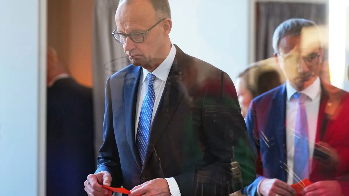 Bundestag - Kanzlerwahl: 06.05.2025, Berlin: Der designierter Bundeskanzler Friedrich Merz (CDU, l), gibt im Bundestag bei der Kanzlerwahl seinen Stimmzettel ab. Im Bundestag findet die Wahl und Vereidigung des Bundeskanzlers und der neuen Bundesregierung statt. Foto: Michael Kappeler/dpa +++ dpa-Bildfunk +++