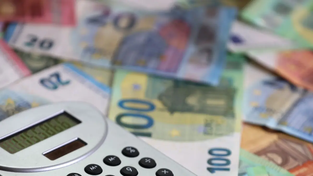 ILLUSTRATION - 15.05.2024, Bayern, Kaufbeuren: ILLUSTRATION Ein Taschenrechner liegt auf verschiedenen Euro-Banknoten. Klamme Kommunen sollen schneller Geld bekommen. (zu dpa: «Klamme Kommunen sollen drei Milliarden Euro früher bekommen») Foto: Karl-Josef Hildenbrand/dpa +++ dpa-Bildfunk +++