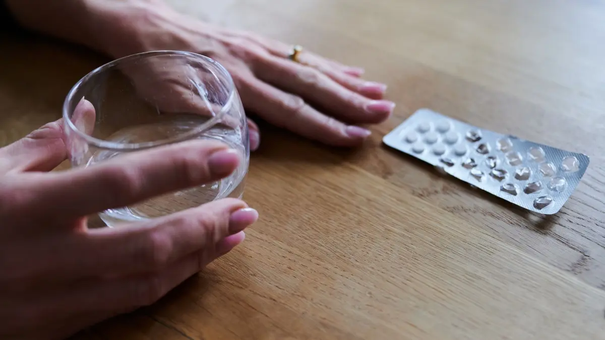 Tabletten: PRODUKTION - 17.04.2023, Berlin: Eine Frau hält ein Glas Wasser in den Händen und greift zu Tabletten. (zu dpa: «Kasse: Deutlich mehr Herz-Kreislauf-Medikamente verordnet») Foto: Annette Riedl/dpa +++ dpa-Bildfunk +++