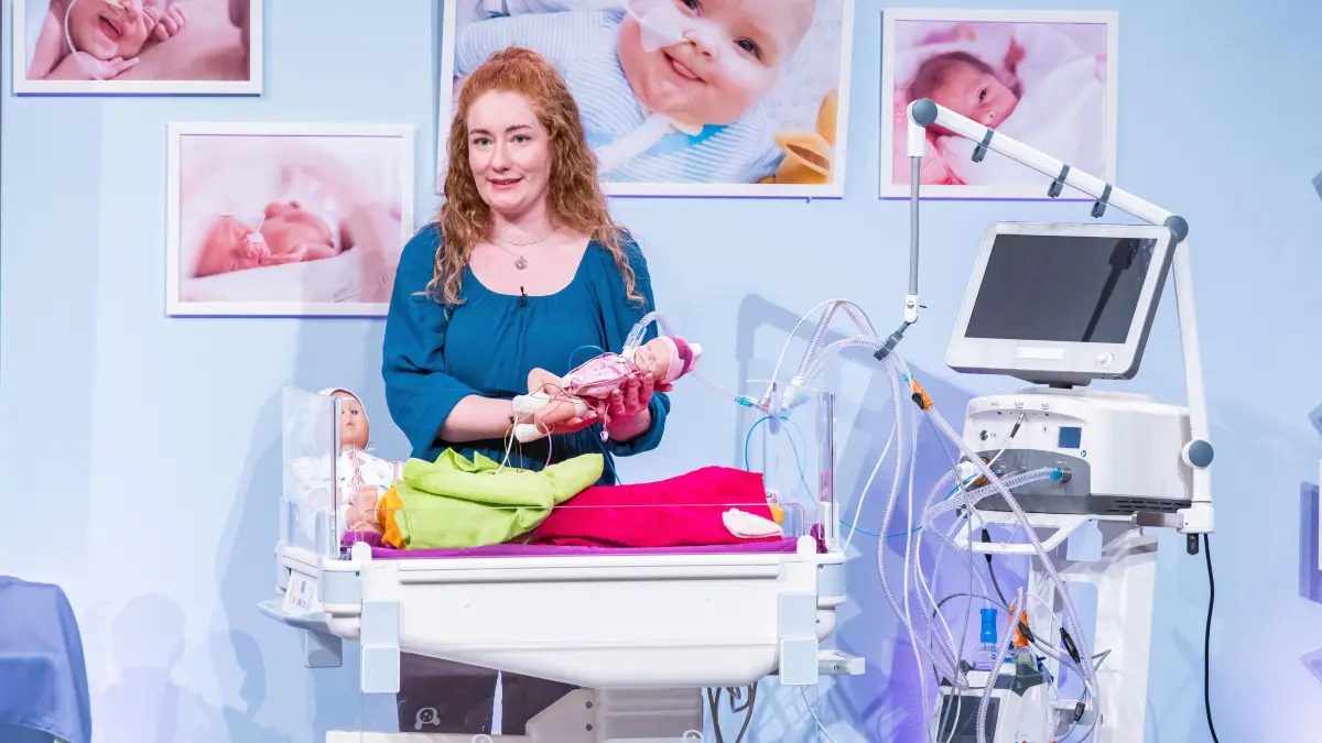 Jennifer präsentieren den Löwen die Sonderbekleidung für Frühgeborene.