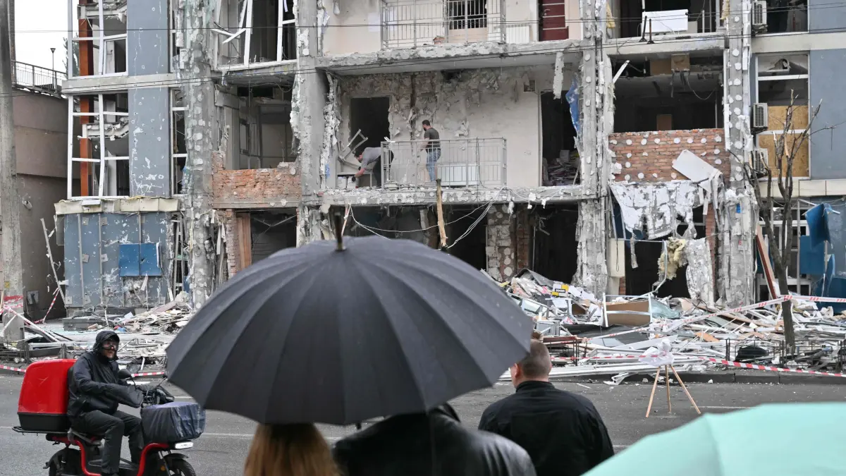 People look at a multistory residential building damaged following a drone strike in Kyiv on May 25, 2025, amid Russian invasion in Ukraine. Russia launched a record number of drones against Ukraine and killed 12 people across the country, officials said on May 25, even as Kyiv and Moscow completed their biggest prisoner exchange since the start of the war. (Photo by Sergei SUPINSKY / AFP)