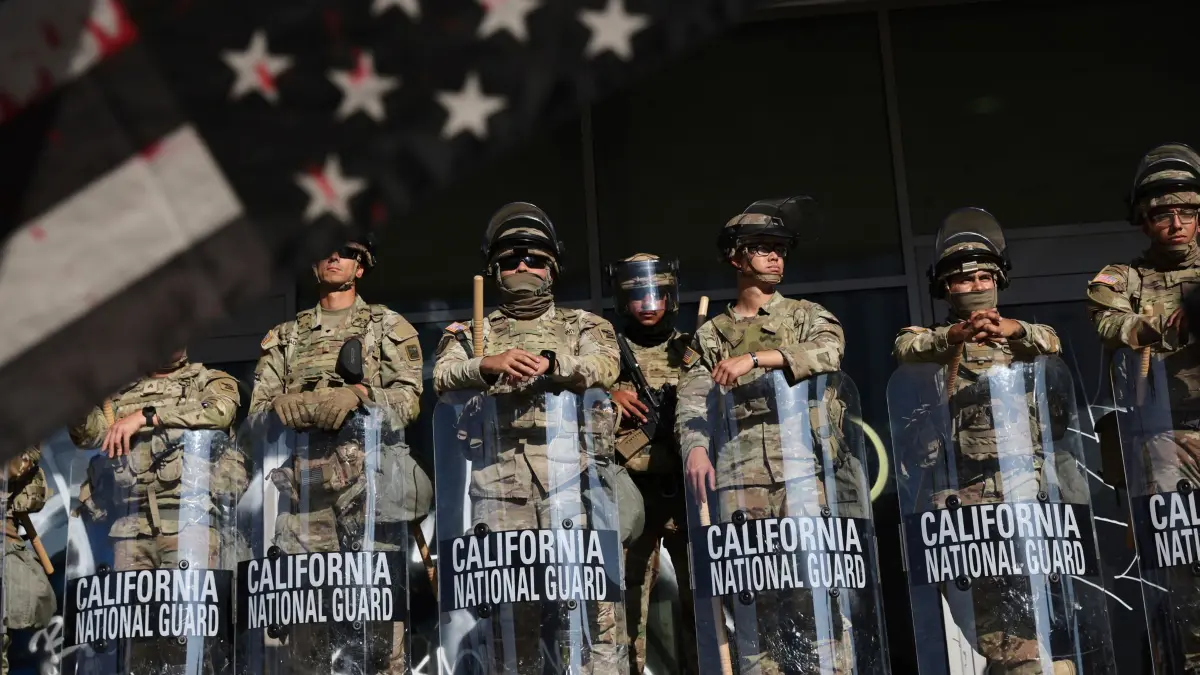 Proteste in Kalifornien - Los Angeles: 10.06.2025, USA, San Francisco: Soldaten der Nationalgarde sind während Protesten als Reaktion auf eine Reihe von Razzien der Einwanderungs- und Zollbehörde der Vereinigten Staaten (ICE) im ganzen Land in der Nähe eines Eingangs zu einem Bundesgebäude in Los Angeles postiert. Foto: Gabrielle Lurie/San Francisco Chronicle/AP/dpa - ACHTUNG: Nur zur redaktionellen Verwendung und nur mit vollständiger Nennung des vorstehenden Credits +++ dpa-Bildfunk +++