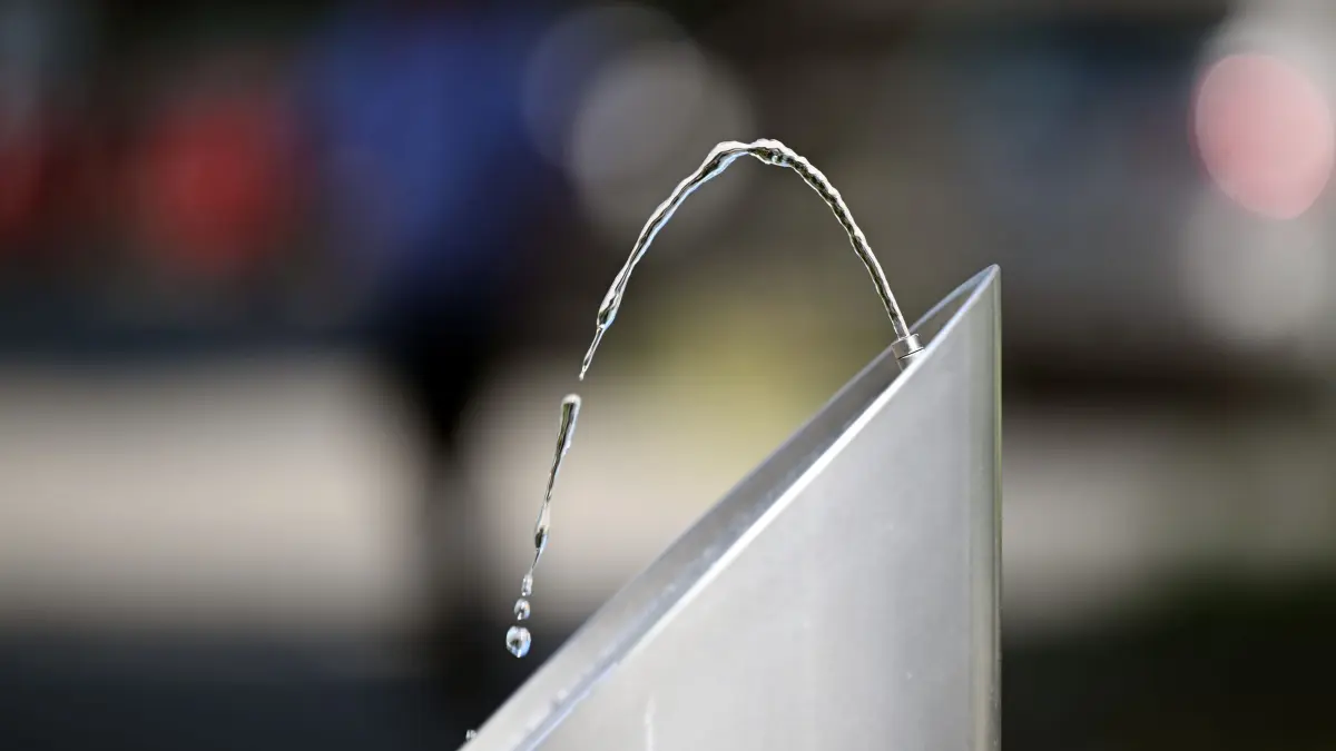 Hitze in Deutschland - Düsseldorf: 01.07.2025, Nordrhein-Westfalen, Düsseldorf: In einer kleinen Fontäne sprudelt Wasser aus einem Trinkwasserspender. Um die Gesundheit bei der Hitze zu schonen, gilt es in den nächsten Tagen besonders ab den Mittagsstunden die Sonne zu meiden, an Sonnenschutz zu denken und genug zu trinken. Foto: Federico Gambarini/dpa +++ dpa-Bildfunk +++