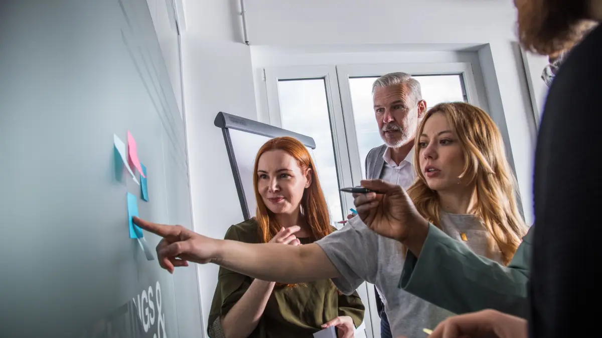 Mehrere Personen an einer Tafel mit Klebezetteln: ILLUSTRATION - Von Zeitmanagement bis Rhetorik: Die Auswahl an Seminaren für Bildungsurlaub ist groß. (zu dpa: «3 Tipps wie Sie Ihren Bildungsurlaub angehen») Foto: Christin Klose/dpa Themendienst/dpa-mag - Honorarfrei nur für Bezieher des Dienstes dpa-Magazin +++ dpa-Magazin +++