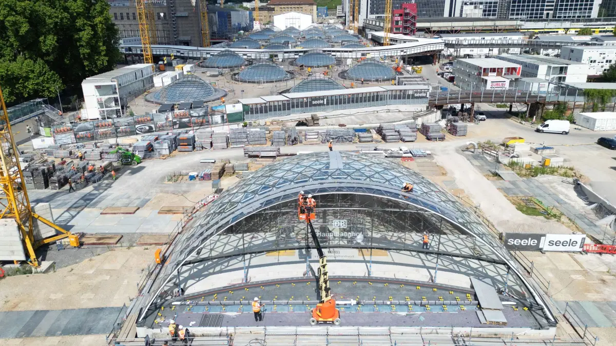 ARCHIV - 11.07.2025, Baden-Württemberg, Stuttgart: Bauarbeiter arbeiten an einem weitgehend fertiggestellten Eingangsportal für den neuen Tiefbahnhof im Rahmen des milliardenschweren Bahnprojekts Stuttgart 21. (zu dpa: «Bahn: S21-Entscheidung wirkt sich nicht auf Ticketpreis aus») Foto: Bernd Weißbrod/dpa +++ dpa-Bildfunk +++