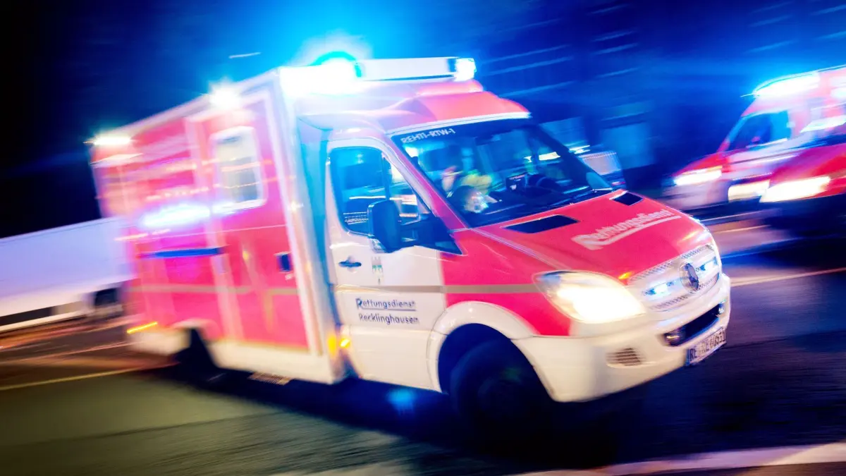 Rettungswagen im Einsatz: ARCHIV - 17.10.2015, Nordrhein-Westfalen, Recklinghausen: ILLUSTRATION - Ein Rettungswagen der Feuerwehr fährt mit Blaulicht durch eine Straße. (zu dpa: «Mann mit Schussverletzung in Recklinghausen gefunden») Foto: Marcel Kusch/dpa +++ dpa-Bildfunk +++
