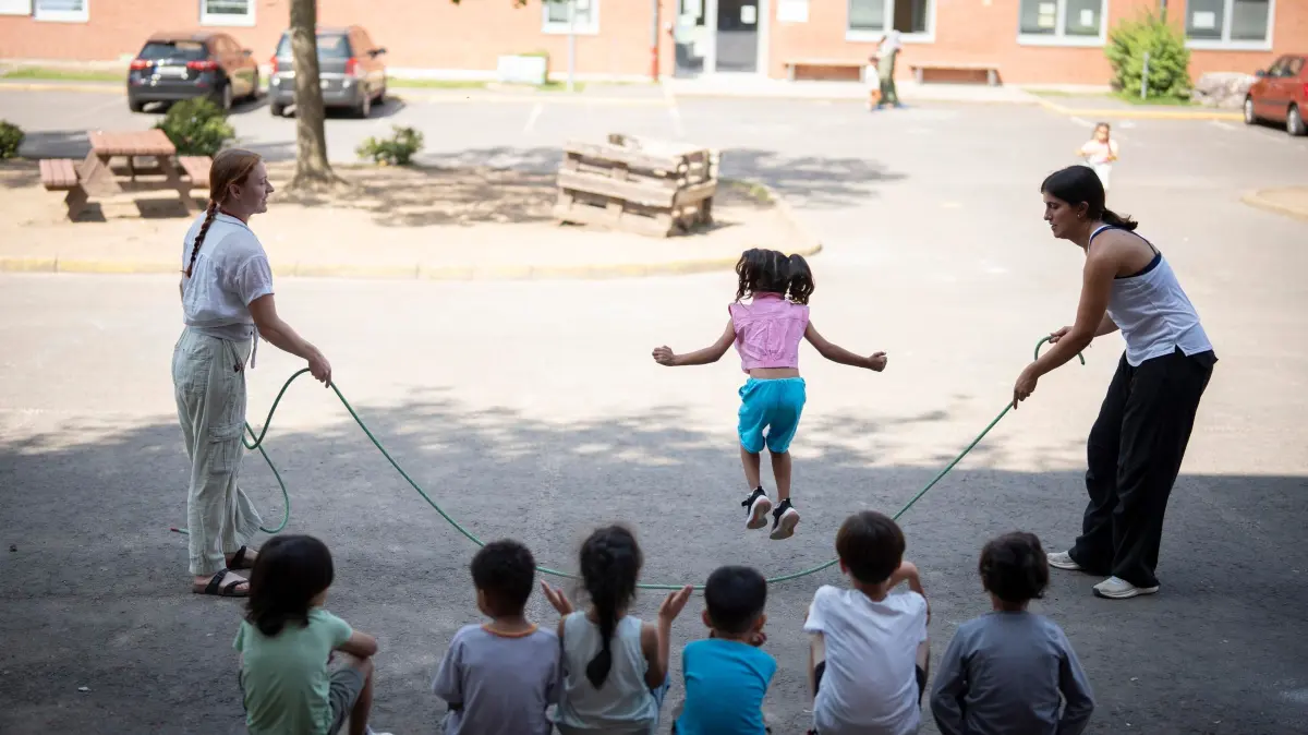 Junge Freiwillige kuemmern sich um Fluechtlinge: Kinder und Freiwillige beim Seilspringen in der Erstaufnahmeeinrichtung des Landes Hessen (EAEH) in Giessen (Foto vom 13.08.2025). Teilnehmer des Workcamps der Organisation "ICJA Freiwilligenaustausch weltweit" wohnen zwei Wochen lang in einer Kirchengemeinde und organisieren tagsueber Angebote fuer die Fluechtlinge in der Giessener Erstaufnahmeeinrichtung. (Siehe epd-Bericht vom 31.08.2025)