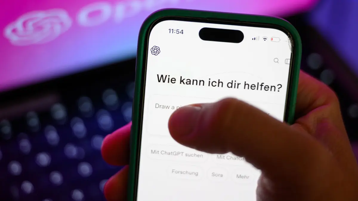 ILLUSTRATION - Ein Smartphone mit dem KI-Chatbot ChatGPT ist vor dem Logo des US-Softwareunternehmens OpenAI zu sehen. KI könnte auch im Unterricht helfen. (zu dpa: «KI könnte im Unterricht helfen»)