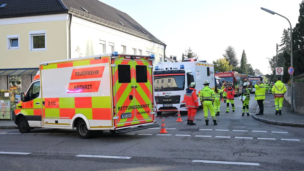 Brand in München - Großeinsatz von Polizei und Feuerwehr: 01.10.2025, Bayern, München: Einsatzkräfte und Fahrzeuge der Feuerwehr sind auf einer Straße zu sehen. Ein Brand in einem Münchner Einfamilienhaus hat einen Großeinsatz von Polizei und Feuerwehr ausgelöst. Es kam deswegen zu größeren Verkehrsbehinderungen, eine Gefahr für die Bevölkerung bestehe nicht, sagte ein Polizeisprecher am Morgen. Foto: Felix Hörhager/dpa +++ dpa-Bildfunk +++