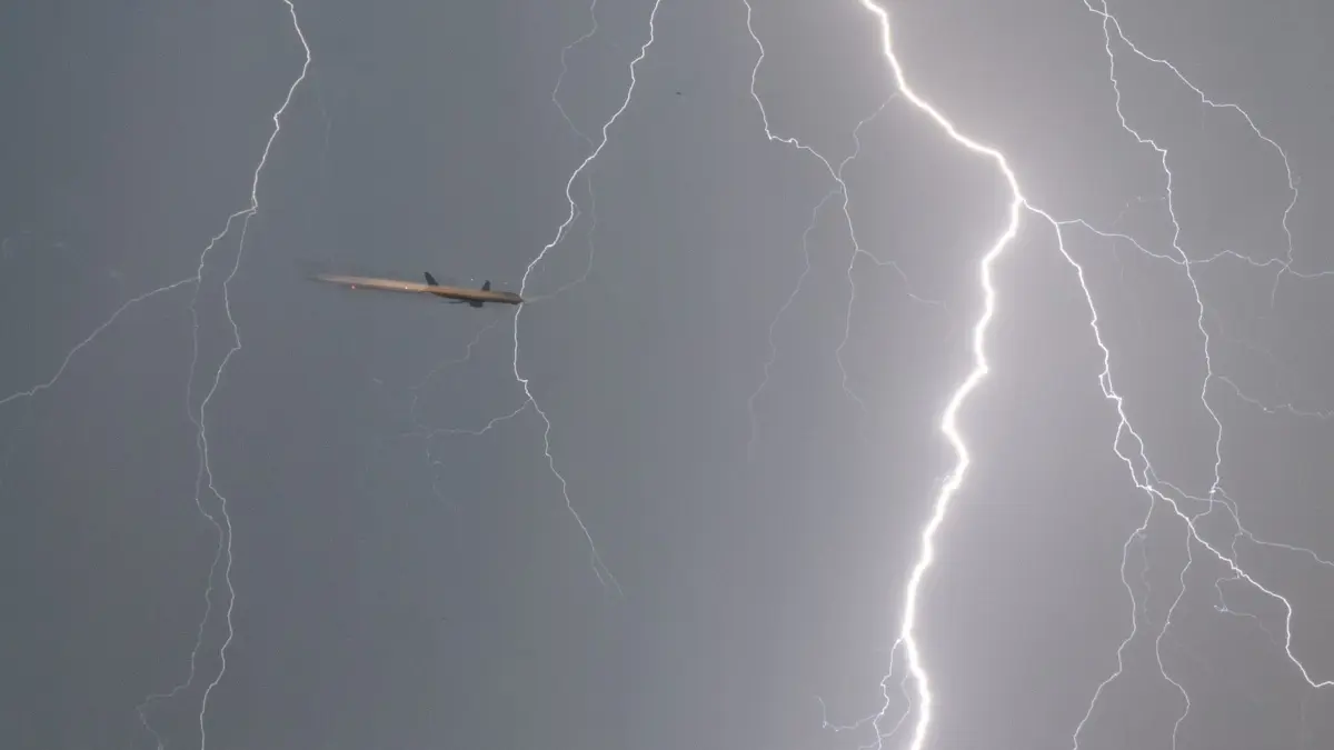 Landung im Gewitter: ARCHIV - 30.06.2022, Hessen, Frankfurt/Main: ILLUSTRATION - Ein Blitz durchzuckt den Abendhimmel während sich ein Flugzeug (l) im Landeanflug auf den Frankfurter Flughafen befindet. Bei einer Belichtungszeit von 1/8 Sekunde wird das Flugzeug vom Blitz angeleuchtet. (zu dpa: «Keine Entschädigung bei Flugverspätung wegen Blitzschlags») Foto: Frank Rumpenhorst/dpa +++ dpa-Bildfunk +++