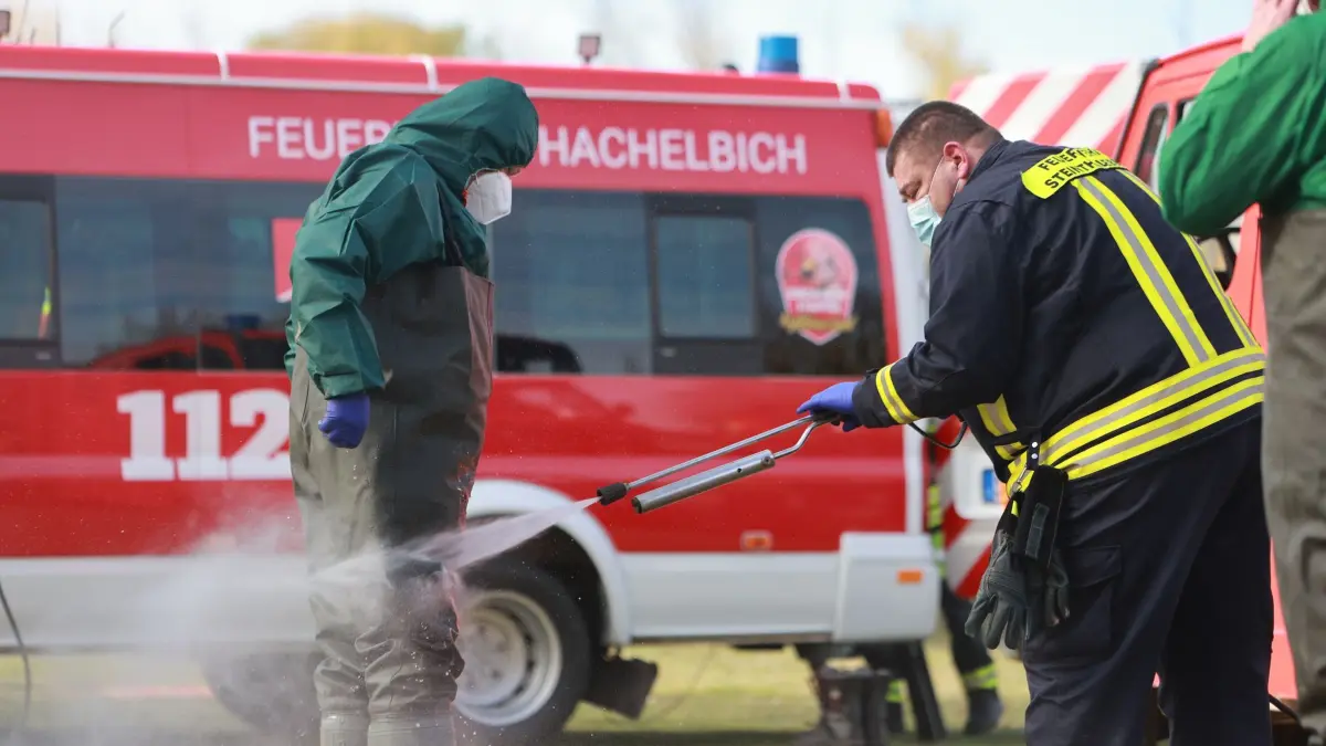 Vogelgrippe am Stausee Kelbra ausgebrochen: 19.10.2025, Thüringen, Kelbra: Einsatzkräfte der Feuerwehr werden nach der Suche nach verendeten Tieren am Stausee Kelbra desinfiziert. Täglich werden am Stausee in Kelbra tote Tiere eingesammelt. Sie sind der Vogelgrippe zum Opfer gefallen. (zu dpa: «Vogelgrippe am Stausee Kelbra - über 100 tote Kraniche») Foto: Matthias Bein/dpa +++ dpa-Bildfunk +++