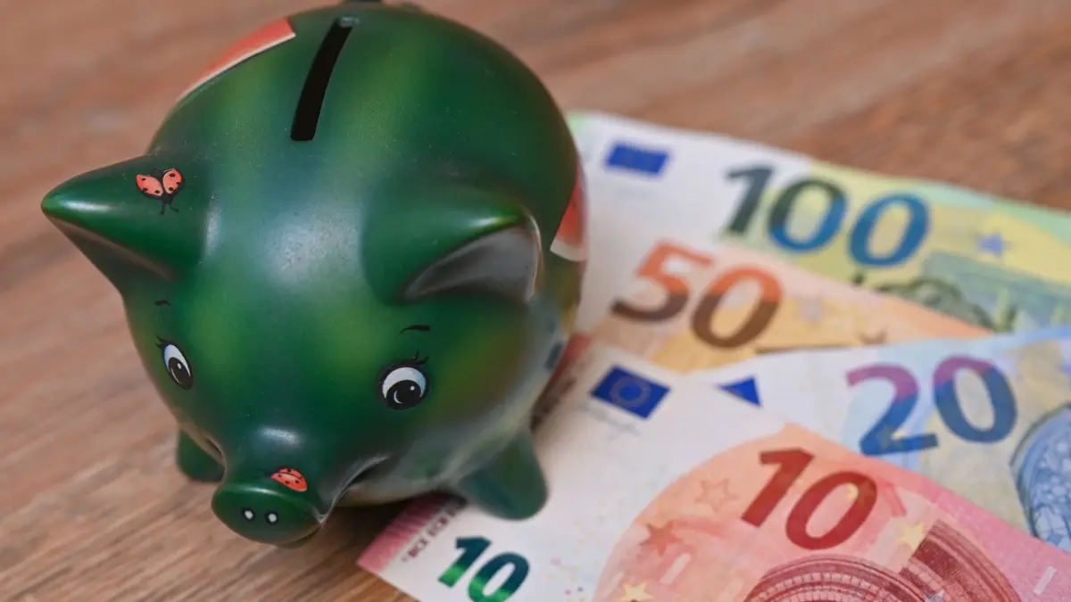 Sparen: ARCHIV - 05.10.2021, Brandenburg, Sieversdorf: Ein Sparschwein steht auf einem Tisch neben Eurobanknoten. (Symbolbild) (zu dpa: «Hessische Finanzexperten geben Tipps für junge Menschen») Foto: Patrick Pleul/dpa-Zentralbild/dpa +++ dpa-Bildfunk +++