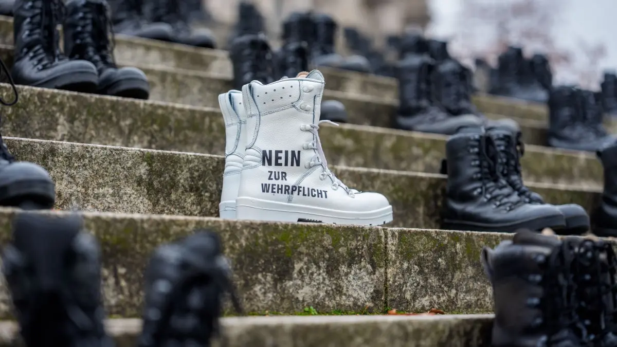 Verteidigungsausschuss im Bundestag: 10.11.2025, Berlin: Aktivisten von „Greenpeace“ haben Bundeswehrstiefel mit der Aufschrift „Nein zur Wehrpflicht“ vor dem Bundestag aufgestellt. Bei einer Experten Anhörung des Verteidigungsausschusses des Bundestages zum Wehrdienst-Gesetz soll über die Wehrpflicht beraten werden. Foto: Michael Kappeler/dpa +++ dpa-Bildfunk +++