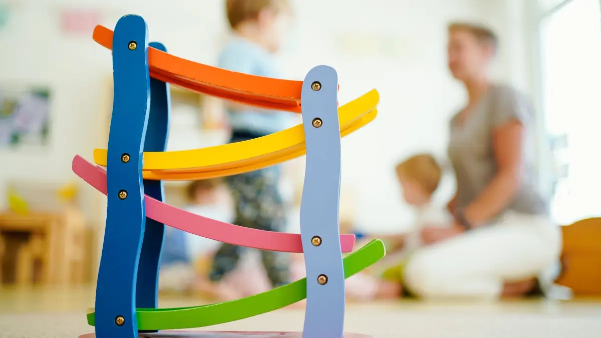 Kita: ARCHIV - 29.06.2020, Baden-Württemberg, Schriesheim: Eine Erzieherin spielt in einer Kindertagesstätte hinter einer Rollbahn mit Kindern. (zu dpa: «Kita-System instabil – Experten fordern mehr Gesundheitsschutz») Foto: Uwe Anspach/dpa +++ dpa-Bildfunk +++