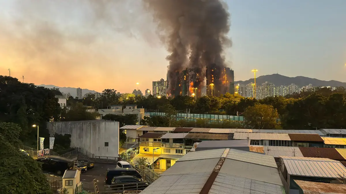 Thick smoke and flames rise as a major fire engulfs several apartment blocks at Wang Fuk Court in Hong Kong's Tai Po district on November 26, 2025. Four people died after multiple blocks in a Hong Kong residential estate went up in flames on November 26, with local media earlier reporting that some residents were trapped. (Photo by Yan ZHAO / AFP)