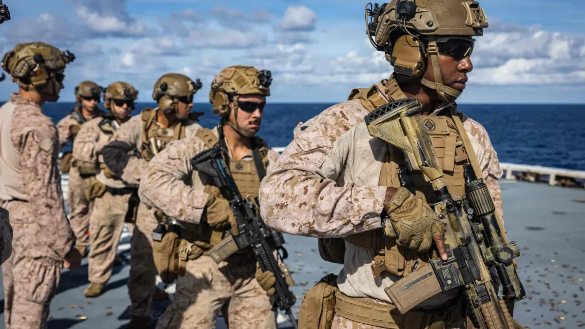 US-Venezuela crisis: This handout photo from the US Marine Corps taken on November 25, 2025 and released on December 2, 2025, shows Marines with India Company, Battalion Landing Team 3/6, 22nd Marine Expeditionary Unit (Special Operations Capable), preparing to engage targets during a deck shoot aboard the San Antonio-class amphibious transport dock USS Fort Lauderdale (LPD 28) in the Caribbean Sea. The United States has "only just begun" targeting alleged drug-trafficking boats, US Defense Secretary Pete Hegseth insisted on December 2, despite a growing outcry over strikes that critics say amount to extrajudicial killings. President Donald Trump has deployed the world's biggest aircraft and an array of other military assets to the Caribbean, insisting they are there for counter-narcotics operations. Regional tensions have flared as a result of the strikes and the military buildup, with Venezuela's leftist leader Nicolas Maduro accusing Washington of using drug trafficking as a pretext for "imposing regime change" in Caracas. (Photo by Sgt. Nathan Mitchell / US MARINE CORPS / AFP) / RESTRICTED TO EDITORIAL USE - MANDATORY CREDIT "AFP PHOTO / US MARINE CORPS / Sgt. Nathan Mitchell" - HANDOUT - NO MARKETING NO ADVERTISING CAMPAIGNS - DISTRIBUTED AS A SERVICE TO CLIENTS
