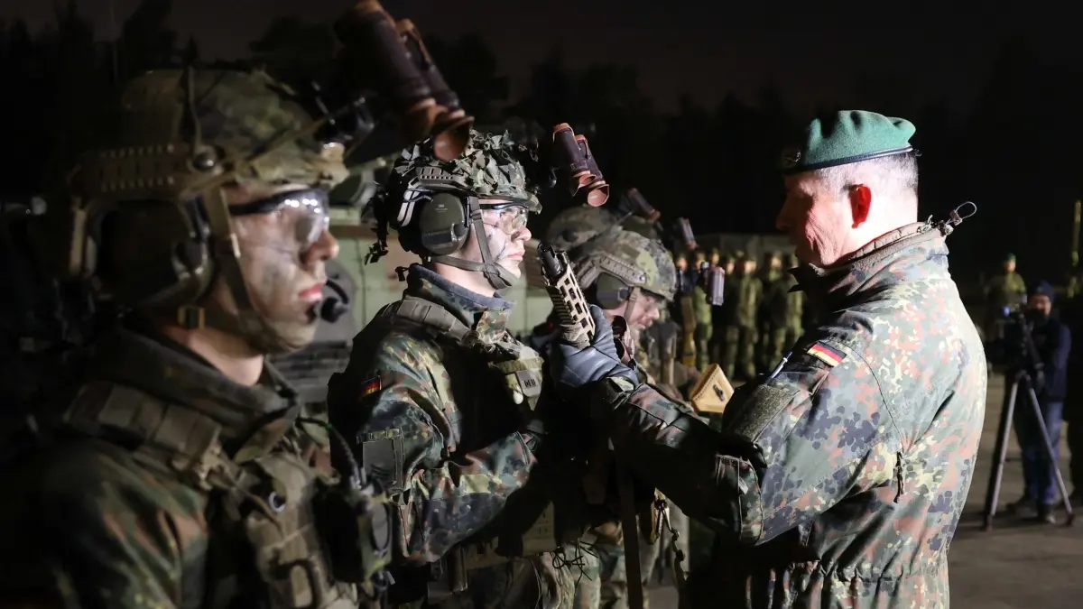 Bundeswehr erhält neues Sturmgewehr G95: 04.12.2025, Bayern, Grafenwöhr: Der Stellvertreter des Inspekteurs des Heeres, Generalleutnant Heico Hübner (r), übergibt Soldaten des Panzergrenadierbataillons 122 aus Oberviechtach das Sturmgewehr G95 von Heckler & Koch auf dem Truppenübungsplatz Grafenwöhr. Die Bundeswehr erhält erste Modelle des neuen Sturmgewehrs G95. Das neue Standardgewehr ist der Nachfolger des G36. Die Waffen werden auf dem Truppenübungsplatz Grafenwöhr an Soldaten des Panzergrenadierbataillon 122 übergeben. Foto: Daniel Karmann/dpa +++ dpa-Bildfunk +++