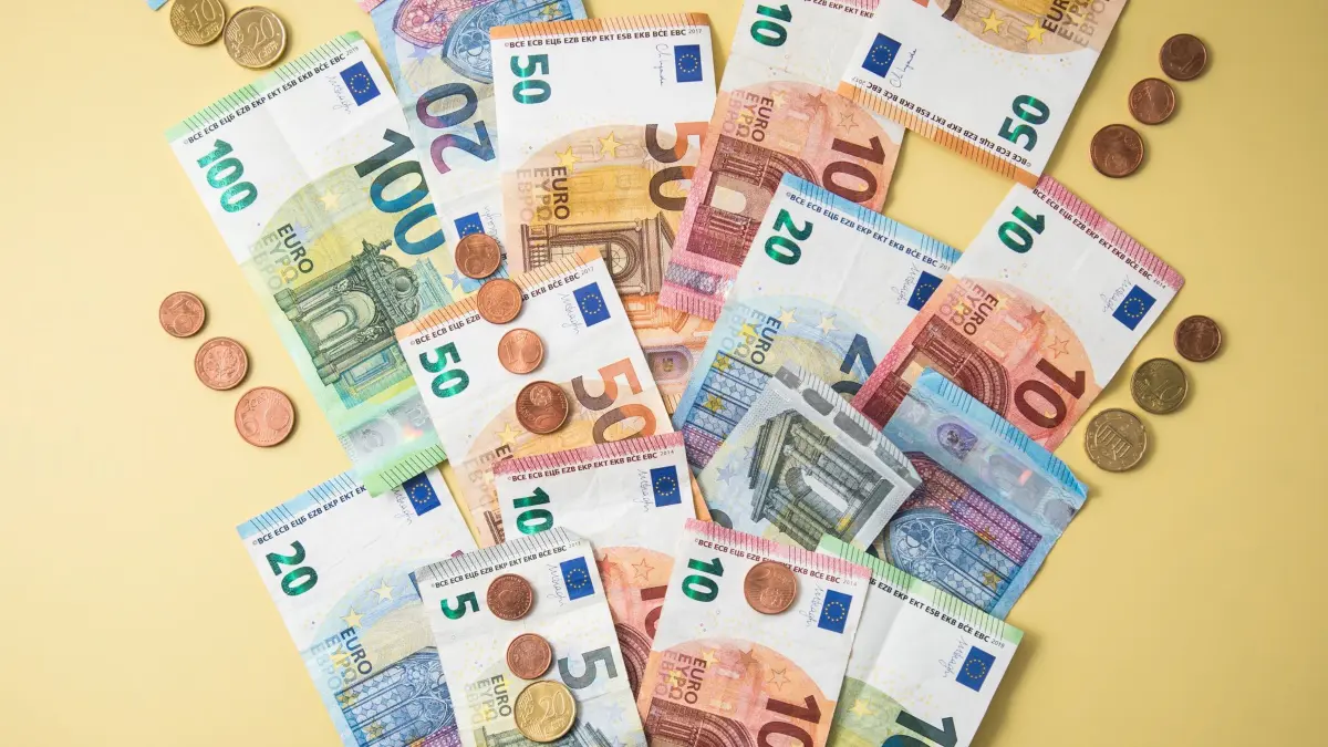 Geldscheine und Münzen fliegen aus einer Geldbörse: ILLUSTRATION - Regelmäßig mehr Geld? In vielen Fällen müssen Beschäftigte dafür eigenständig mit dem Arbeitgeber verhandeln. (zu dpa: «Habe ich einen Anspruch auf eine Gehaltserhöhung?») Foto: Christin Klose/dpa-mag/dpa - Honorarfrei nur für Bezieher des Dienstes dpa-Magazin +++ dpa-Magazin +++