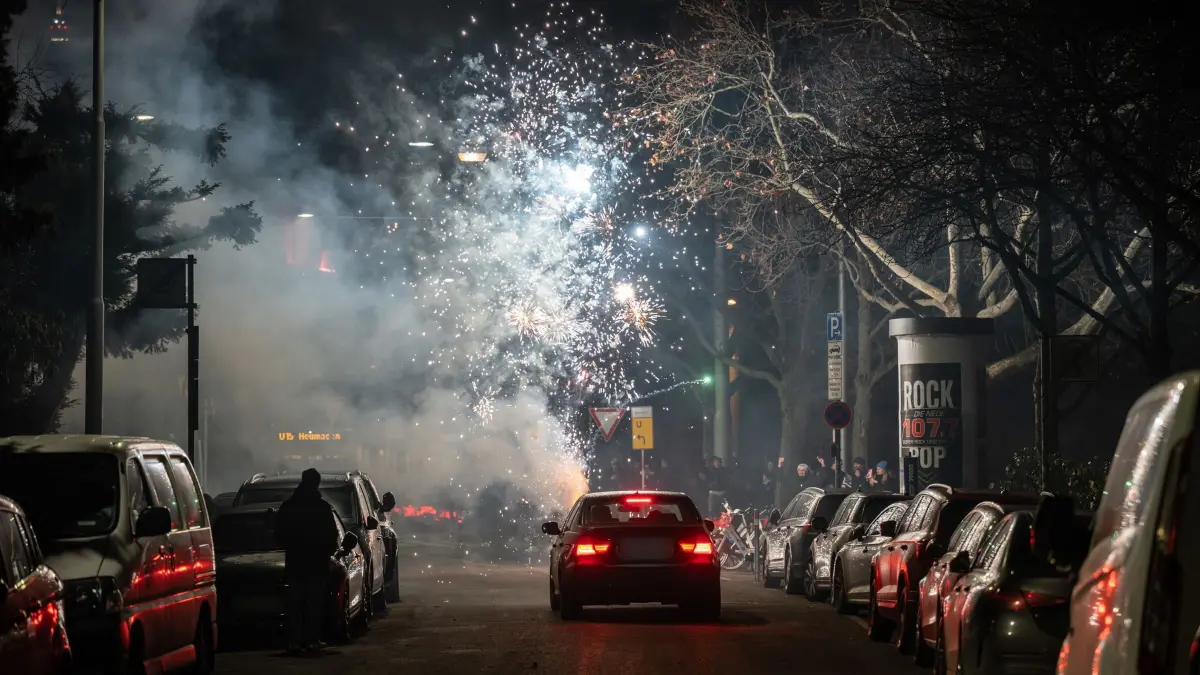 Silvester - Stuttgart: 01.01.2026, Baden-Württemberg, Stuttgart: Eine Feuerwerksbatterie wird auf einer Straße vor einem Auto losgelassen. Foto: Silas Stein/dpa - ACHTUNG: Kennzeichen wurde(n) aus rechtlichen Gründen gepixelt +++ dpa-Bildfunk +++