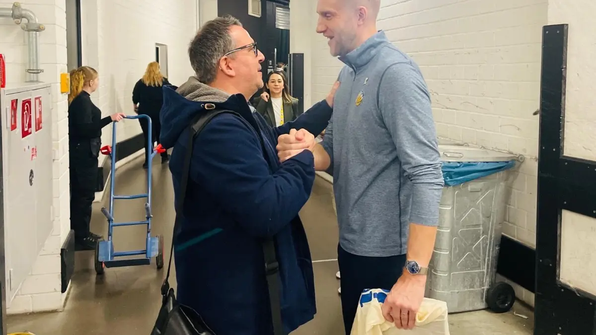 Nach der Pressekonferenz haben wir das Geschenk an Tuomas Iisalo übergeben. Es befindet sich in der Tüte, die er in der Hand hält.