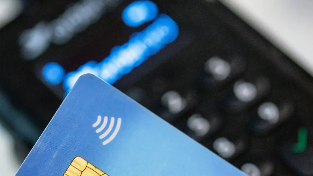 ARCHIV - 15.06.2023, Berlin: Eine Person hält ihre Girokarte über ein EC-Lesegerät zwecks kontaktlosem Bezahlen. (zu dpa: «Polizei warnt vor falschem Netto-Shop im Internet») Foto: Fernando Gutierrez-Juarez/dpa +++ dpa-Bildfunk +++