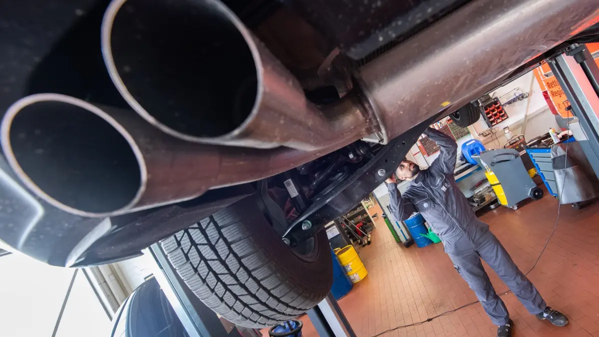 Autowerkstatt: ARCHIV - 22.07.2020, Niedersachsen, Sehnde: Ein Auszubildender zum KfZ-Mechatroniker steht unter einem VW Touran in einer Werkstatt. (zu dpa: «Verivox: Autoversicherer haben 2025 erneut Preise erhöht») Foto: Julian Stratenschulte/dpa +++ dpa-Bildfunk +++