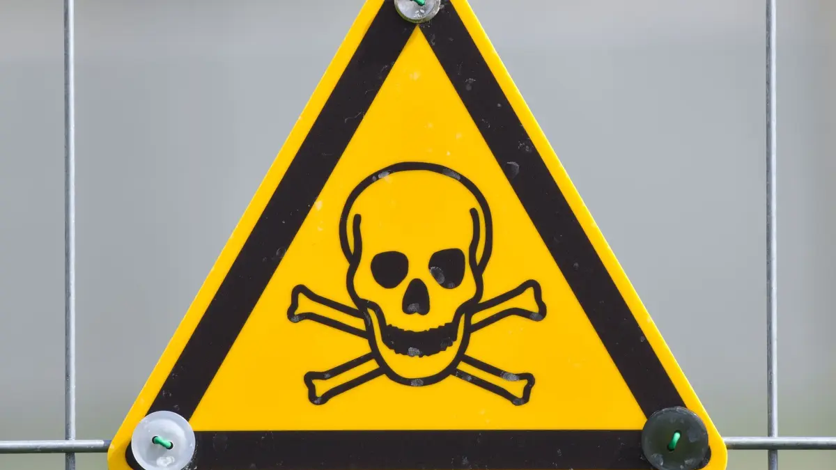 Warnschild: ARCHIV - 07.04.2015, Rheinland-Pfalz, Landau in der Pfalz: Ein Warnschild mit einen Totenkopf-Symbol hängt am 08.04.2015 in Landau (Rheinland-Pfalz) an einem Bauzaun. (zu dpa: «Quecksilber auf Straße im Altmarkkreis Salzwedel gefunden») Foto: Uwe Anspach/dpa +++ dpa-Bildfunk +++