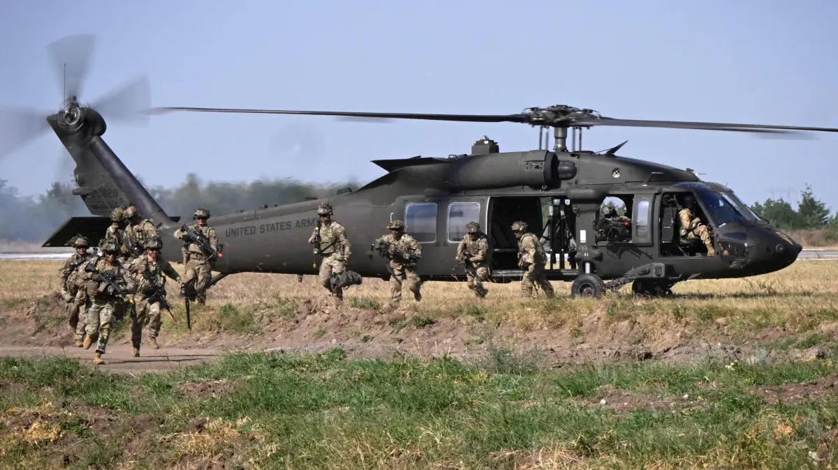 (FILES) Military personnel of the US Army's 101st Airborne Division leave a helicopter during a demonstration drill at Mihail Kogalniceanu Airbase near Constanta, Romania on July 30, 2022. Romania decided on March 11, 2026 to let the United States use air bases in the eastern European country to refuel aircraft involved in the US-Israeli war on Iran, the country's president said. The United States would be able to use the Mihail Kogalniceanu base near Constanta and Campia Turzii in central Romania for an initial 90 days, an official source told AFP. An extra 400 US troops will be deployed at each of the two bases. After Washington decided in October to withdraw some troops from the country, some 1,000 US military personnel remained, 800 at the MK base. (Photo by Daniel MIHAILESCU / AFP)