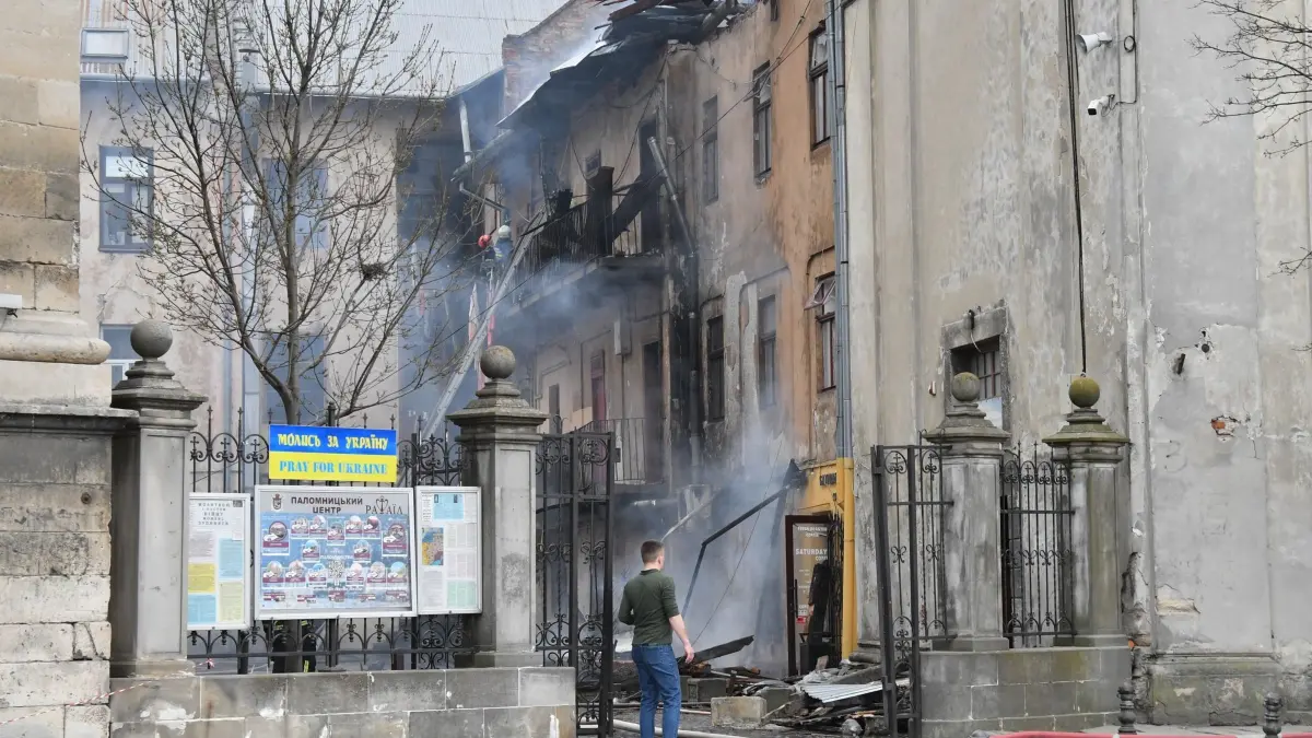 Ukraine-Krieg - Lwiw: 24.03.2026, Ukraine, Lwiw: Feuerwehrleute löschen ein Feuer im Stadtzentrum nach einem russischen Drohnenangriff. Foto: Mykola Tys/AP/dpa +++ dpa-Bildfunk +++