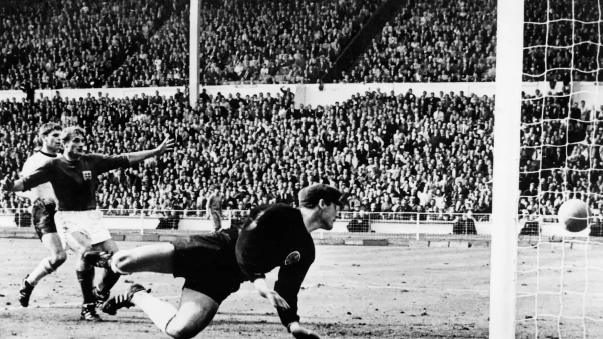(FILES) West Germany's goalkeeper Hans Tilkowski watches the ball bounce off the crossbar following a shot by English forward Geoff Hurst (not pictured) as English forward Roger Hunt (arms raised) and West Germany's defender Wolgang Weber look on during the overtime period of the World Cup final on July 30, 1966 at Wembley stadium in London. The Beatles and the miniskirt were all the rage when England hosted the World Cup for the sport they had invented 103 years earlier. A record 70 countries entered the tournament, but African nations decided to boycott the event because the champion from their region was forced to play against the Asian champion to secure a place. The final, played at the “temple” of Wembley, was not without controversy. England beat Germany 4–2 in extra time thanks to a “ghost goal” by Geoff Hurst, who scored three goals in the final – a feat matched only by Kylian Mbappe more than half a century later. (Photo by CENTRAL PRESS / AFP)
