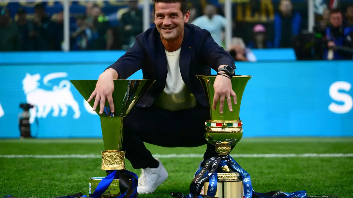 Inter Milan's Romanian head coach Cristian Chivu poses with the trophies for the Italian Cup and the 21st scudetto (Italian Championship victory) at San Siro stadium after the Italian Serie A football match between Inter Milan and Hellas Verona in Milan, on May 17, 2026. (Photo by Marco BERTORELLO / AFP)