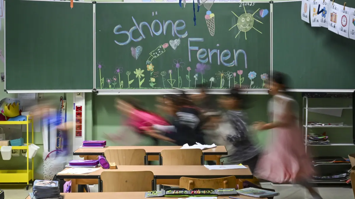 „Schöne Ferien“ steht auf einer bemalten Schultafel in der Schule in der Köllnischen Heide zum letzten Schultag der Klasse 1c vor den Sommerferien in Berlin und Brandenburg. Schüler und Schülerinnen laufen in schnellem Tempo aus dem Klassenzimmer. +++ dpa-Bildfunk +++