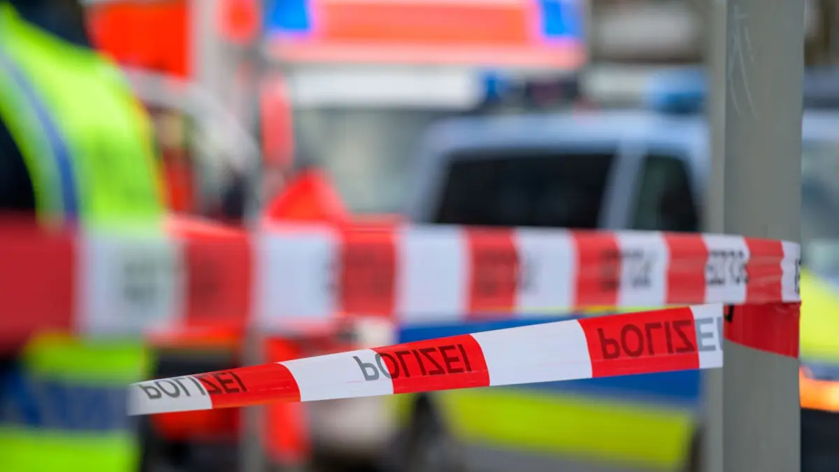 Flatterband: ARCHIV - 26.02.2022, Hamburg: Einsatzfahrzeuge von Feuerwehr und Polizei stehen hinter dem mit Flatterband abgesperrten Einsatzort. (zu dpa: «Vater und Sohn schwer verletzt gefunden - Sohn stirbt») Foto: Jonas Walzberg/dpa +++ dpa-Bildfunk +++