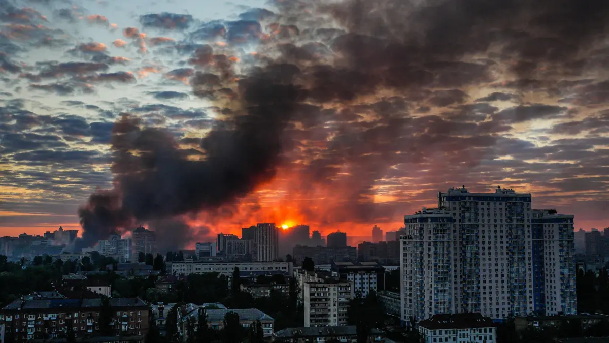 Ukraine-Krieg - Kiew: 24.05.2026, Ukraine, Kiew: Nach einem massiven russischen Luftangriff steigt bei Sonnenaufgang Rauch über der Stadt auf. Foto: Zoya Shu/AP/dpa +++ dpa-Bildfunk +++
